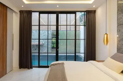 a bedroom with a bed and a large window at Cozy Seminyak Loft 360 in Seminyak
