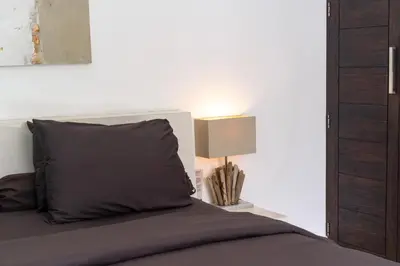 a bedroom with a bed and a lamp on a table at Villa Minha Gente Seminyak in Seminyak