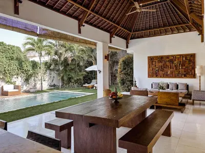 a living room with a wooden table and a pool at Villa Chocolat Seminyak 2 Bedroom in Seminyak