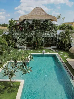 a swimming pool in front of a villa at Villa Chocolat Seminyak 6 Bedroom in Seminyak