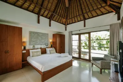 a bedroom with a bed and a large window at Villa Chocolat Seminyak 6 Bedroom in Seminyak