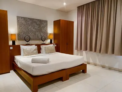 a bedroom with a large bed with white sheets at Villa Chocolat Seminyak 6 Bedroom in Seminyak