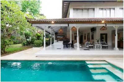 a house with a swimming pool in front of a house at Villa Hari in Seminyak