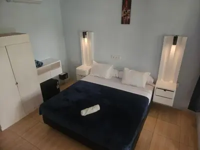 a bedroom with a large bed with a blue blanket at Two Brothers Guesthouse in Legian