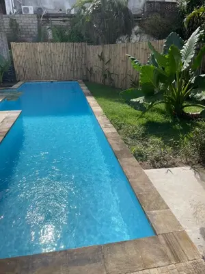 a small blue swimming pool in a yard at Two Brothers Guesthouse in Legian