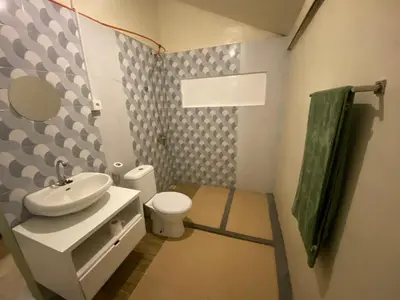a bathroom with a white sink and a toilet at Two Brothers Guesthouse in Legian
