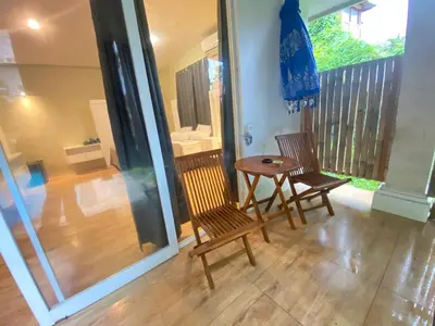 a patio with two chairs and a table on a balcony at Two Brothers Guesthouse in Legian