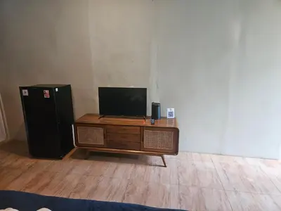 a television sitting on a table next to a refrigerator at Two Brothers Guesthouse in Legian
