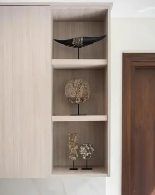 a shelf with two vases and a bird on it at The Mango Villa Jimbaran Jimbaran in Jimbaran