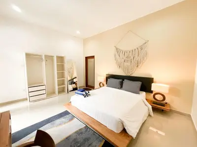 a bedroom with a large white bed and a table at Villa Sayang 2 in Seminyak