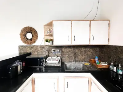 a kitchen with a sink and a microwave at Villa Sayang 2 in Seminyak