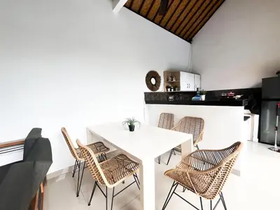 a dining room with a white table and chairs at Villa Sayang 2 in Seminyak