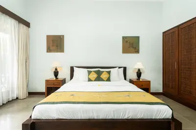 a bedroom with a large bed with two night stands at Lacita Villa Seminyak in Seminyak