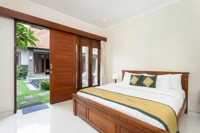 a bedroom with a bed and a large window at Lacita Villa Seminyak in Seminyak