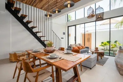 a living room with a wooden table and chairs at Villa Casa Goya - Lofty Pool Villa Near The Beach in Vibrant Legian in Legian
