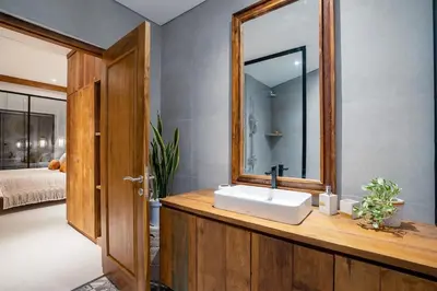 a bathroom with a sink and a mirror at Villa Casa Goya - Lofty Pool Villa Near The Beach in Vibrant Legian in Legian