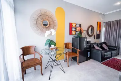 a living room with a glass table and chairs at Rumah Jimbaran Kuta 2 bedroom 6 pax SukaBali 5 in Jimbaran