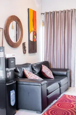 a black leather couch in a living room with a mirror at Rumah Jimbaran Kuta 2 bedroom 6 pax SukaBali 5 in Jimbaran