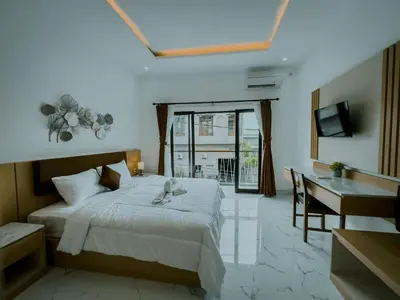 a bedroom with a bed and a desk and a computer at Pachira Living Legian in Legian
