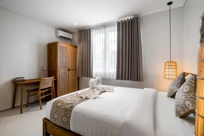 a bedroom with a bed and a desk in it at Villa Umabell Villa Seminyak in Seminyak