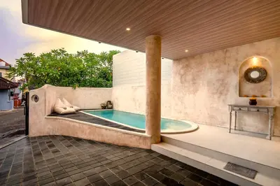 a swimming pool in a house with a bathtub at Villa Umabell Villa Seminyak in Seminyak