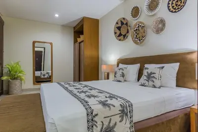 a bedroom with a large bed and a mirror at Luxury 4 Bedroom Villa Seminiak in Seminyak