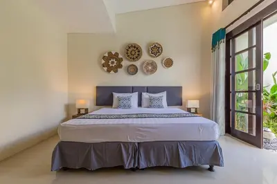 a bedroom with a large bed with two plates on the wall at Luxury 4 Bedroom Villa Seminiak in Seminyak