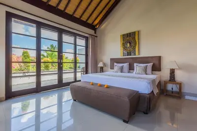 a bedroom with a large bed and a large window at Luxury 4 Bedroom Villa Seminiak in Seminyak