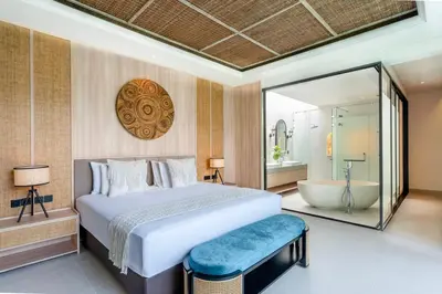 a bedroom with a large bed and a bath tub at Deneva Villa by Betterplace in Canggu