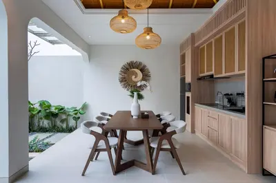 a dining room with a wooden table and chairs at Deneva Villa by Betterplace in Canggu
