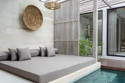 a living room with a couch next to a swimming pool at Deneva Villa by Betterplace in Canggu