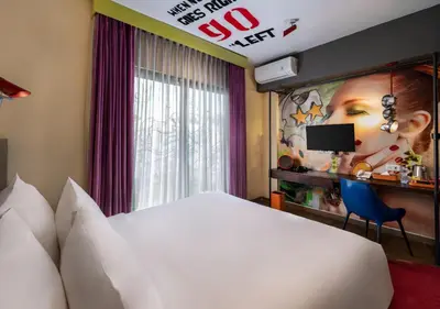 a hotel room with a white bed and a sign at Viva Dash Hotel Seminyak in Seminyak