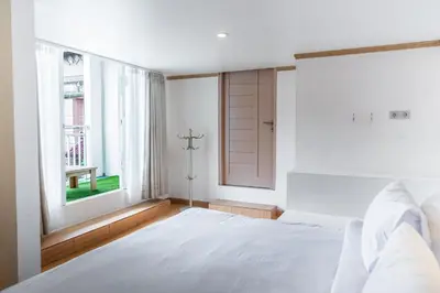 a bedroom with a white bed and a window at House Jimbaran Kuta 3 bedroom 8 pax SukaBali 6 in Jimbaran