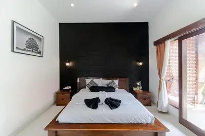 a bedroom with a bed with a bow tie on it at Villa Moza in Canggu
