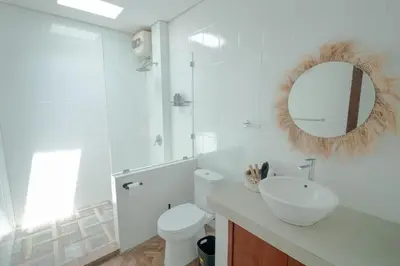 a bathroom with a sink and a toilet and a mirror at Villa Moza in Canggu