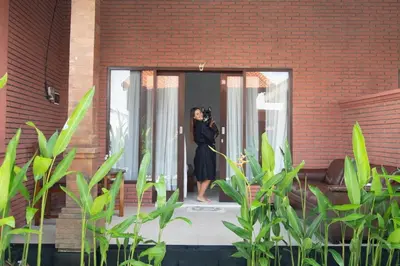 a woman taking a picture of herself in a mirror at Villa Moza in Canggu