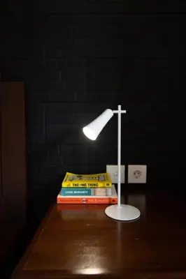 a lamp on a table next to a stack of books at Villa Moza in Canggu