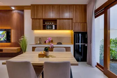 a kitchen and dining room with a wooden table and chairs at Villa Taman Seminyak 44 near Double Six Beach in Seminyak