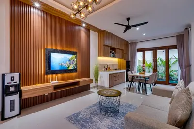 a living room with a couch and a tv on a wall at Villa Taman Seminyak 44 near Double Six Beach in Seminyak
