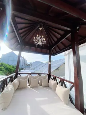 a porch with white pillows and a chandelier at Ara Santvana Villa Bali in Legian