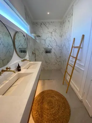 a bathroom with two sinks and two mirrors at Ara Santvana Villa Bali in Legian
