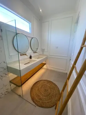 a bathroom with a sink and two mirrors at Ara Santvana Villa Bali in Legian