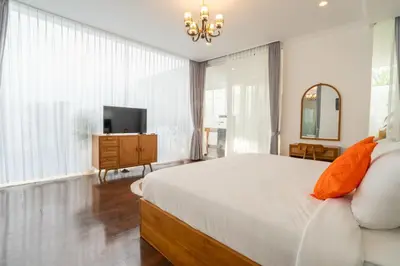 a bedroom with a large bed and a television at Villa Bali Road House Seminyak in Seminyak