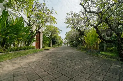 a cobblestone road with trees on either side at Villa Bali Road House Seminyak in Seminyak