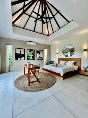 a bedroom with a large bed and a table at 2 BR Villa Near Seminyak Beach in Seminyak