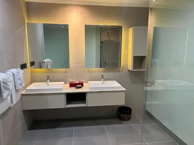a bathroom with two sinks and a mirror at Peninsula Bay Resort in Nusa Dua
