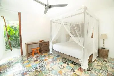a bedroom with a white canopy bed and a table at Villa Sassy - Stunning Private Award Winning Seminyak Oasis in Seminyak