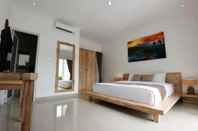 a bedroom with a bed and a mirror and a tv at Bluna Villa seminyak in Seminyak