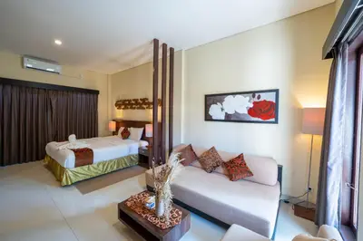 a hotel room with two beds and a couch at The Mupu Seminyak in Seminyak