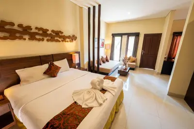 a bedroom with a large bed and a living room at The Mupu Seminyak in Seminyak